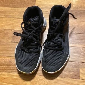 Black and gold Under Armour basketball shoes.